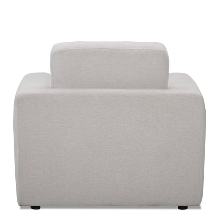 The Lugano Chair showcases a modern gray design with a boxy profile, similar to Italian luxury. It features thick backrests and armrests made from premium materials, sitting on discreet black feet, echoing the elegance of the Lugano Sofa Set.