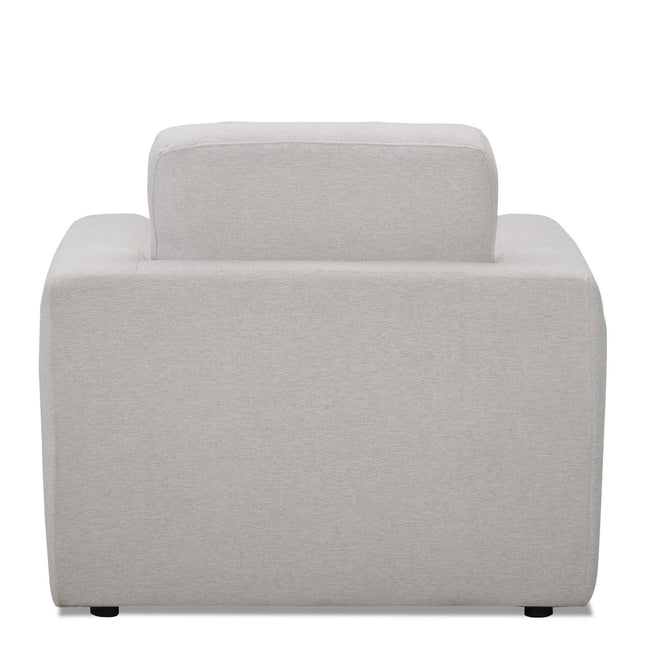The Lugano Chair showcases a modern gray design with a boxy profile, similar to Italian luxury. It features thick backrests and armrests made from premium materials, sitting on discreet black feet, echoing the elegance of the Lugano Sofa Set.
