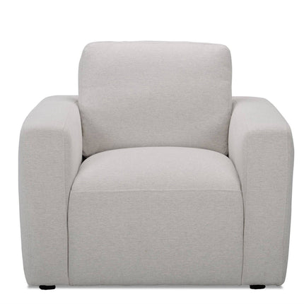 The Lugano Chair is a modern, cushioned armchair in light beige with a wide seat, high backrest, and thick armrests. Crafted from premium materials, its perfect for adding Italian luxury to any contemporary living space.