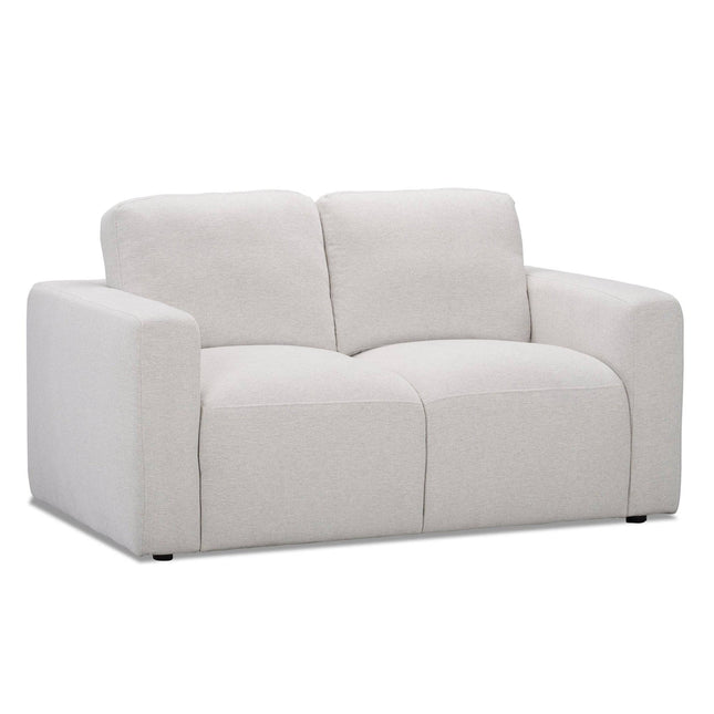 The Lugano Loveseat is a modern, light beige loveseat designed for two, featuring plush cushions and wide armrests. Upholstered in premium materials, its smooth finish and minimalist design exude Italian luxury, making it ideal for a contemporary living room.