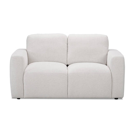 The Lugano Loveseat captures Italian luxury with a minimalist, plush design. This modern white two-seater boasts thick, rounded arms and cushioned backrests. Crafted from premium materials, the fabric is soft and smooth on a plain white backdrop, exuding cozy elegance.