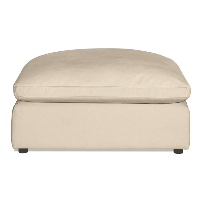 The Peyton Ottoman showcases a minimalist modern style with its beige, rectangular cushion top and simple design. Supported by small dark legs, it provides extra comfort with plush cushioning, making it perfect for any living room or lounge.