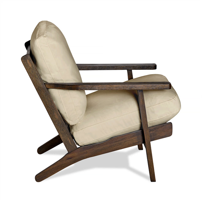 Side view of the Peyton Chair, a stylish mid-century modern piece. It features a wooden frame with angled legs and armrests, dark wood finish, and light beige cushions for contrast. The minimalist design enhances its comfort and elegance.