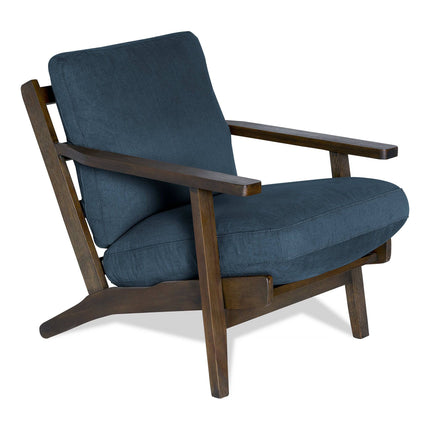 The Peyton Chair is a modern wooden armchair with angled armrests and legs, featuring a dark blue cushioned seat and backrest that blends contemporary design with mid-century charm.