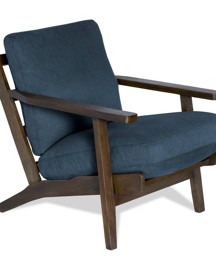The Peyton Chair is a modern wooden armchair with angled armrests and legs, featuring a dark blue cushioned seat and backrest that blends contemporary design with mid-century charm.