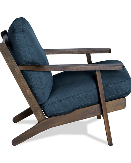 The Peyton Chair showcases a stylish mid-century modern design with a dark wooden frame and deep blue upholstery. It features angled legs and a slightly reclined backrest, blending retro aesthetics with comfort for any living space.