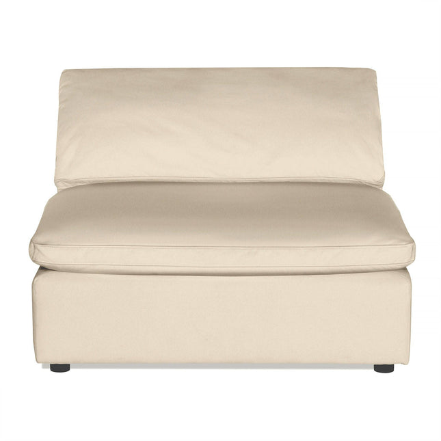 The Peyton Armless chair, with its cushioned seat and backrest, seamlessly fits modern living spaces. Its beige upholstery offers an elegant, minimalist touch, complemented by a low-sleek design with small black feet at the bottom.