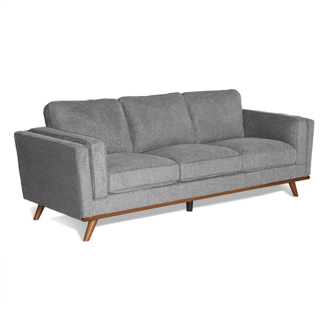 Meet the Maddox Sofa: a sleek gray sofa with minimalist design, plush cushions, and outward-angled wooden legs. This mid-century modern piece adds contemporary flair to any living room.