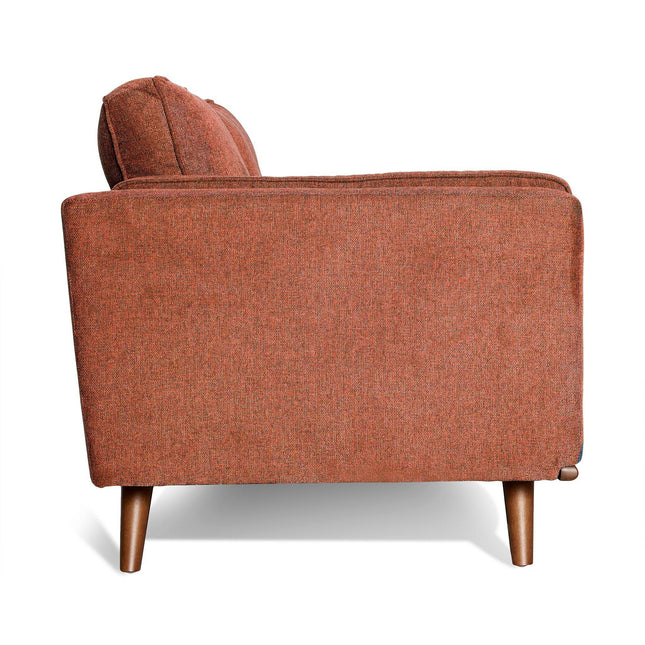 An orange upholstered armchair with a boxy shape and wooden legs, evoking mid-century modern style. It has plush back cushions and a simple, modern design that pairs perfectly with the Maddox Sofa against a white background.