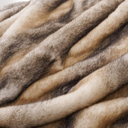 The RCL Fur Throw features a textured surface that mimics faux fur, showcasing tones of brown, beige, and gray for a soft, natural look. This reversible blanket combines the cozy comfort of throw blankets with an elegant touch for any space.